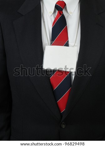 Closeup of a businessman in a suit with an ID Tag hanging around his neck. The tag is blank ready for your copy.