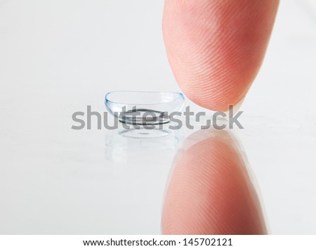 Detail of soft contact lens and finger
