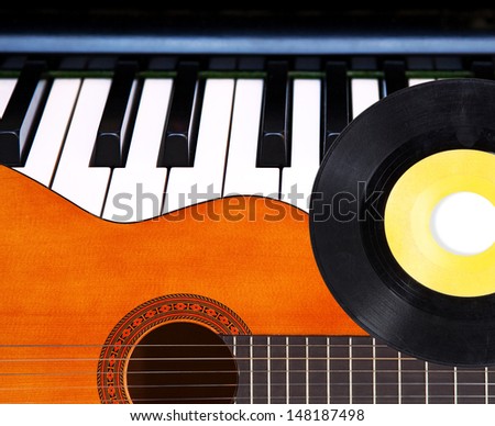 Acoustic guitar, piano keys and vinyl record.
