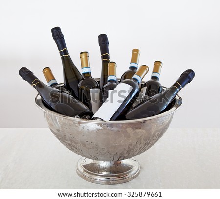 Wine Bottles in a metal bucket on a table.