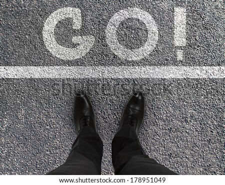 man feet on asphalt road with drawing go