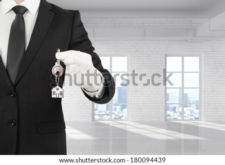 businessman holding a key standing in room