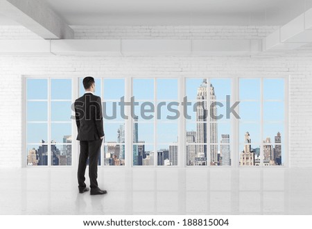 man in suit standing in room and looking at window