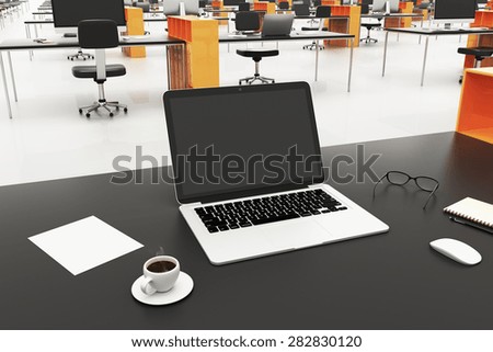 desk with a laptop in a large office