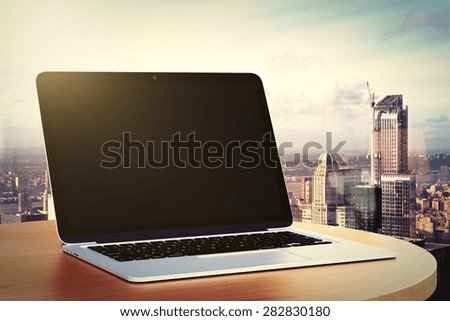 blank laptop on a table by the window
