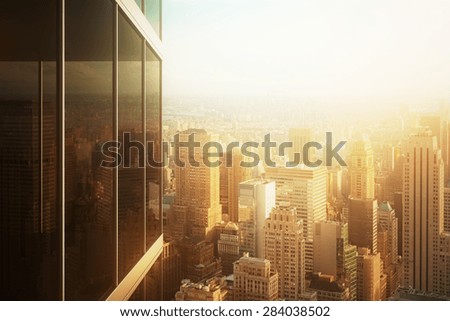 Cityscape reflected in the glass of an office building at sunset