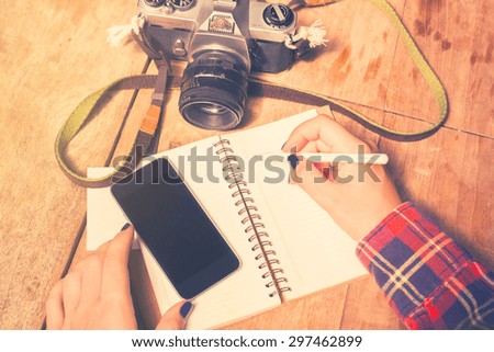 girl with blank cell phone, diary and old camera, vintage photo effect