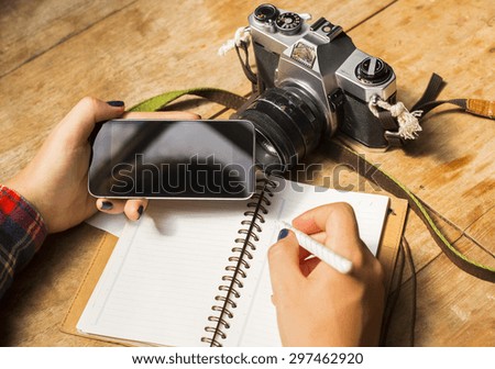 girl with blank cell phone, diary and old camera