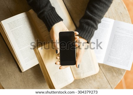 Girl with cell phone and books