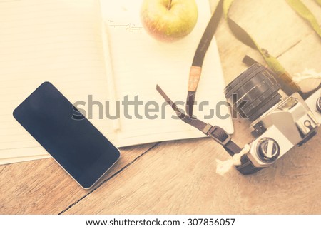 cell phone, diary, old camera and green apple
