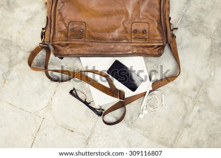 brown leather handbag, cell phone, diary and glasses