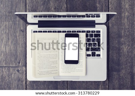 Blank smartphone on open book and laptop on a floor, vintage photo effect, mock up