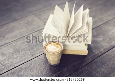 Cup of coffee and pack of books on vintage style floor