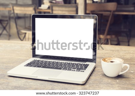 laptop with white screen on a table in a cafe, mock up