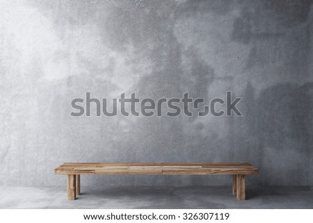 Wooden bench in a room with concrete floor and concrete wall