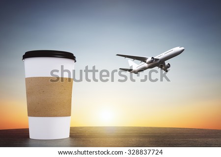 Blank paper cup of coffee on a wooden table and flying away aircraft, travel concept