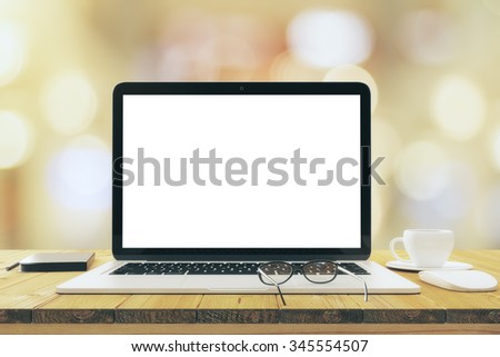 Blank white laptop screen on wooden table with eyeglasses and cup of coffee, mock up