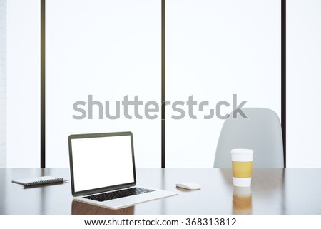 Blank white laptop screen with paper cup on the table with chair in the office, mock up