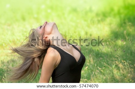 Portrait of young woman with wind blowing hair in the park