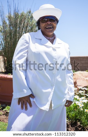Lady dressed in white outside home before church.