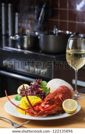 A nice, big plate filled with lobster, rice and a glass of white wine.