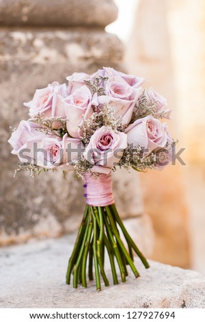 A pink flower bouquet filled with dark pink roses.