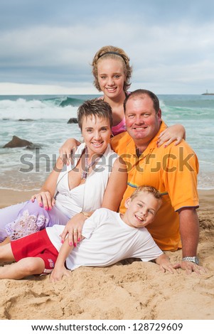 A fun family being photographed on the beach.