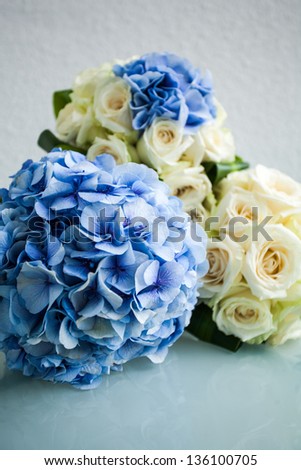 three bouquets with blue hydrangea flowers and white roses
