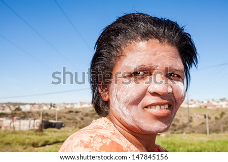 image of an african woman with dried out facial cream to protect her fair skin in the sun and symbolizes a mark of beauty