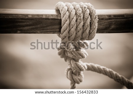 an image of a rope in a sail knot on a wooden bar