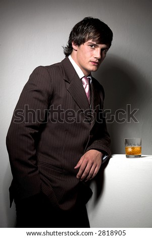 Male model dressed in business suit having a drink
