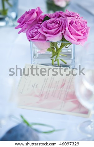 Table decor with a menu and pink roses.