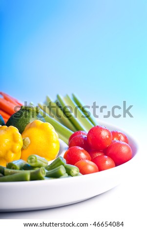 Selection of fresh veg on a spiral white plate.