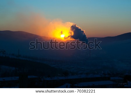 Sunset on the background of smoking chimneys