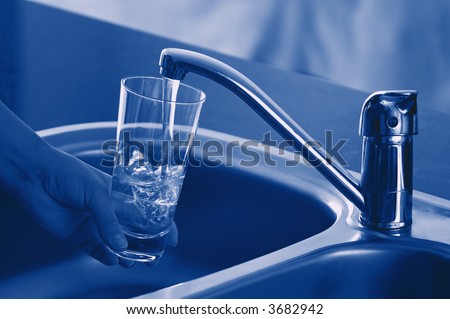Pouring Fresh Tap Water Into a Glass. Shallow DOF. Focus on Tap.
