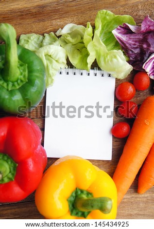 Open note book ready for writing recipe with food ingredients