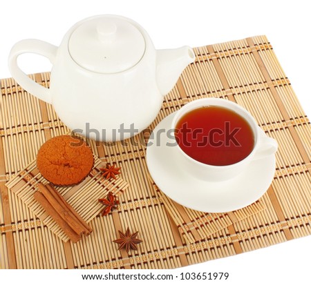 Teapot and cup of tea with spice and muffins on wooden mat, food photo