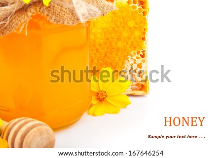 Honey in jar, stick, honeycombs and flowers, food photo