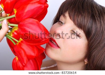 Portrait of beautiful smiling girl with tulips bouquet on white