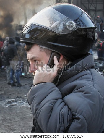 Man in a motorcycle helmet with a mobile phone during street protests