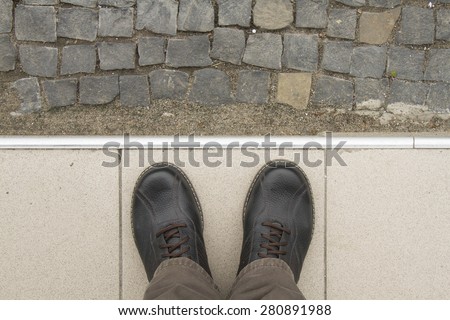 Looking down man feet on cobbled road