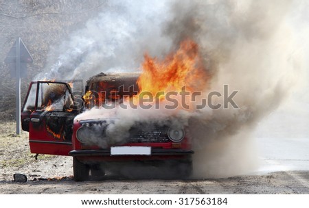 Burning car on desert rural road
