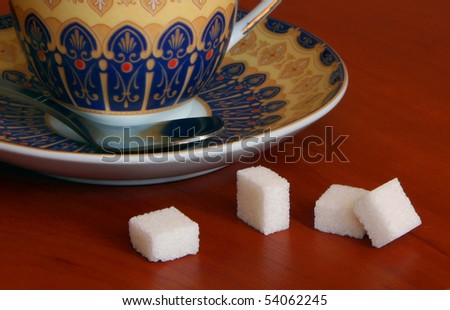Pieces of sugar near a saucer. It is focused on sugar