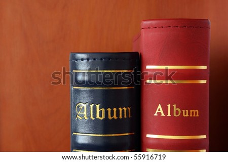 The top part of picture albums of dark blue and red color on a brown background