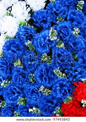 Flowers white blue and red at a memorial wreath
