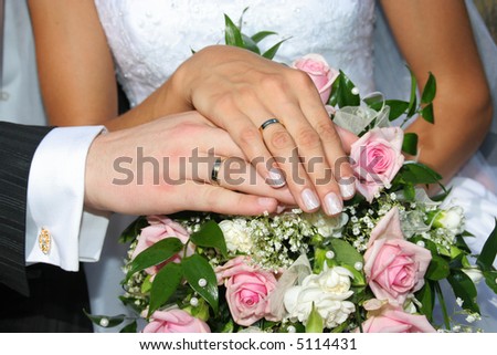 stock photo Hands with wedding rings on the flowers background