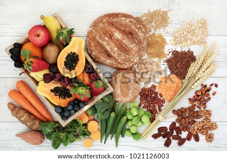 Healthy high fibre diet food concept with legumes, fruit, vegetables, wholegrain bread, cereals, grains, nuts and seeds. Super foods high in antioxidants, anthocyanins, omega 3 and vitamins. Top view.