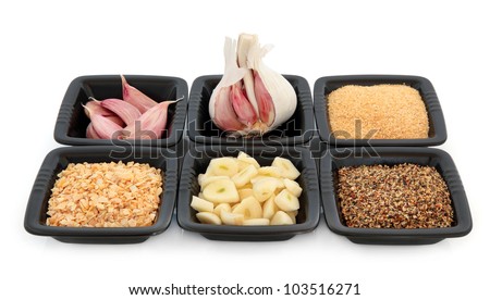 Garlic selection of cloves whole, chopped, flakes, salt granules and pepper flavoured  in black square dishes over white background.