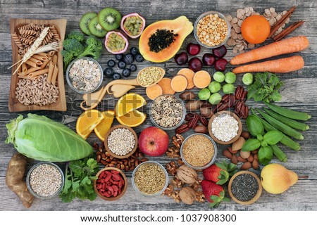 High dietary fibre health food concept with fruit, vegetables, whole wheat pasta, legumes, cereals, nuts and seeds  with foods high in omega 3, antioxidants, anthocyanins, smart carbs and vitamins.