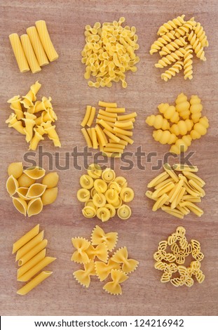 Pasta selection in piles over papyrus background.